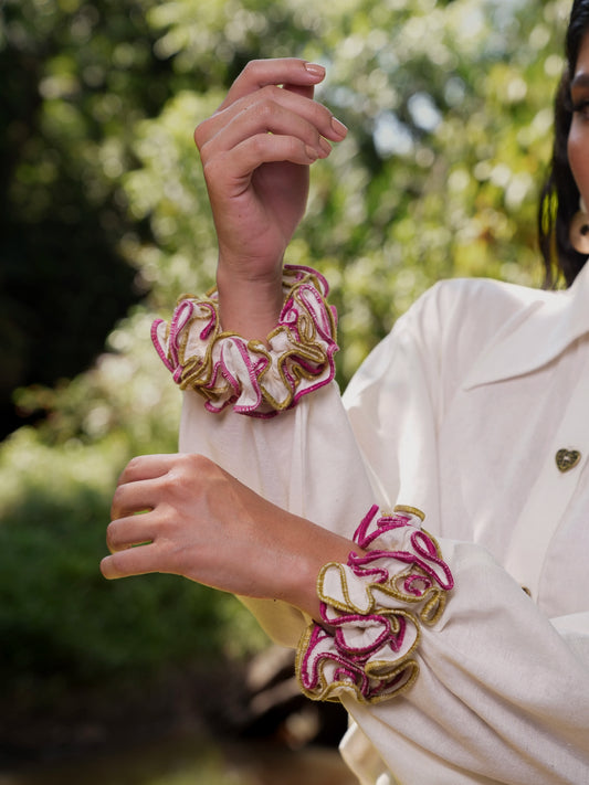 Detalle de los puños con volantes en fucsia y dorado de la Blusa Travesía en lino crema – Ale Ardila Studios