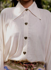 Detalle frontal de la botonera con botones dorados en forma de corazón de la Blusa Travesía – Ale Ardila Studios