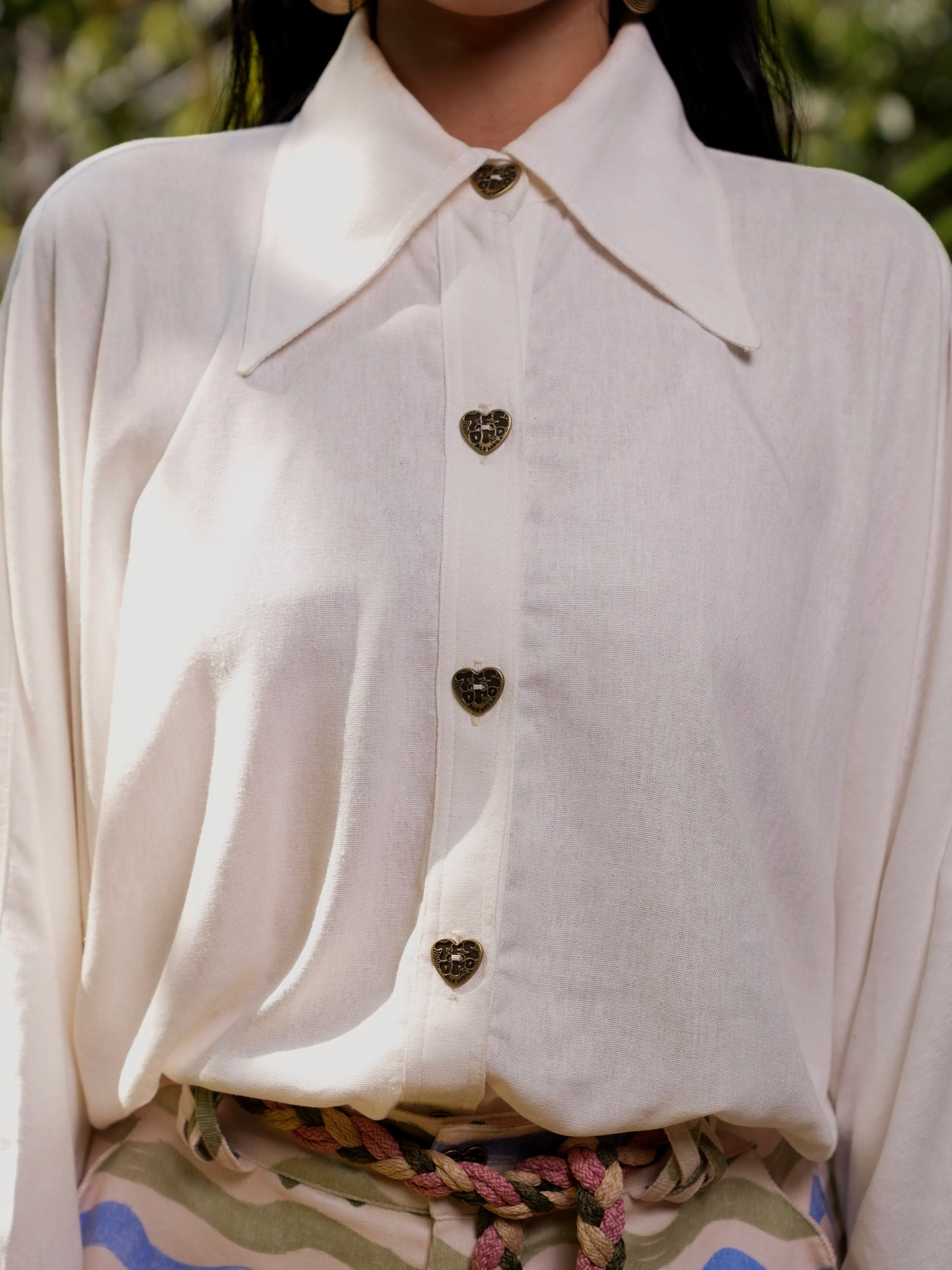 Detalle frontal de la botonera con botones dorados en forma de corazón de la Blusa Travesía – Ale Ardila Studios
