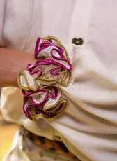 Primer plano del volante fucsia y dorado en el puño de la Blusa Travesía en lino crema – Ale Ardila Studios