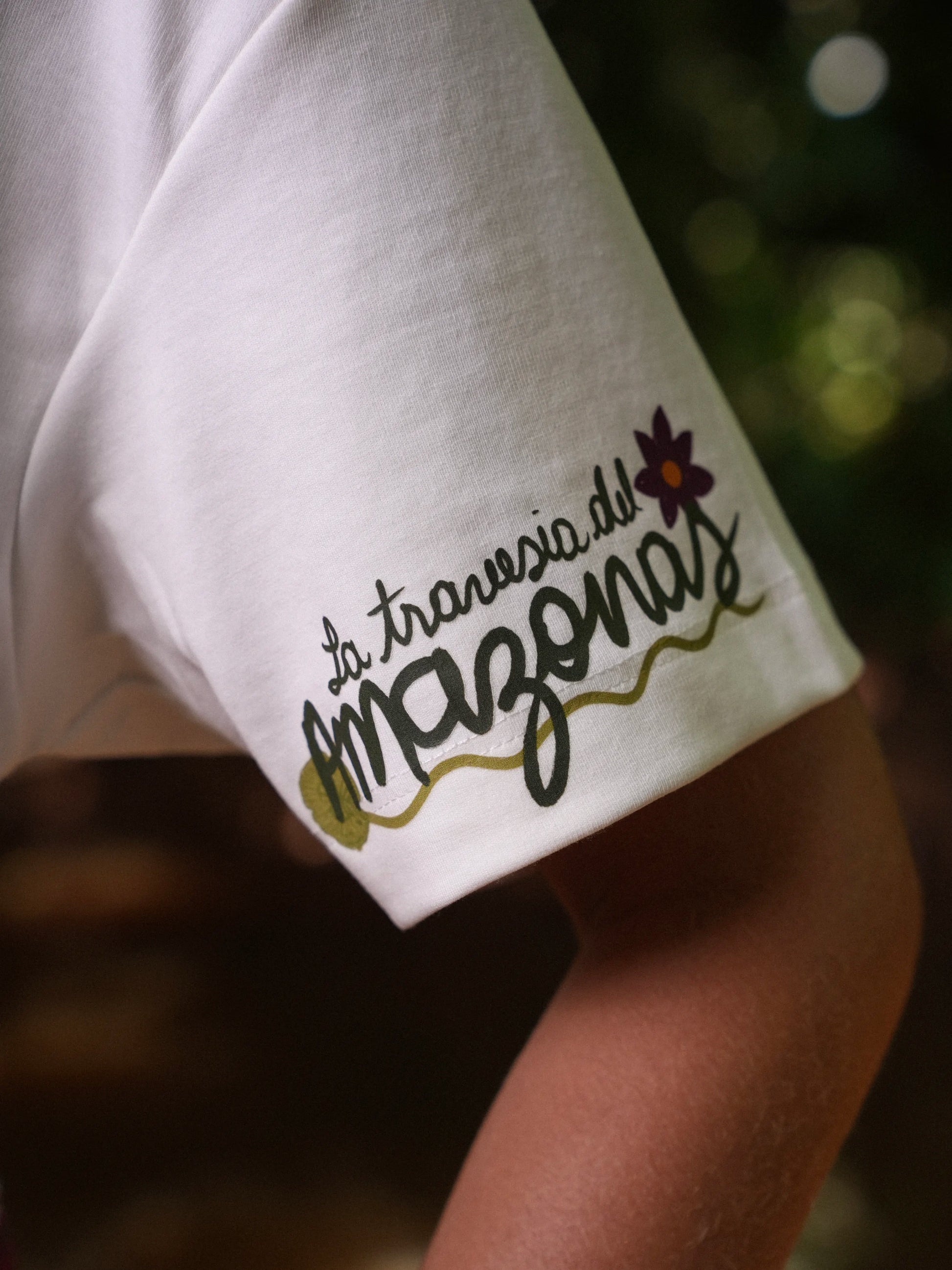 Detalle de la manga con la firma 'la travesía del Amazonas' de la Camiseta Victoria – Ale Ardila Studios